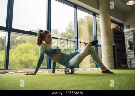 Weibliche Sportlerin beim Training mit Schaumstoffrolle im Health Club Stockfoto