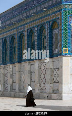 Israel, Jerusalem, Felsendom, muslimische Frau, die in traditioneller Kleidung an der Moschee vorbeigeht. Stockfoto