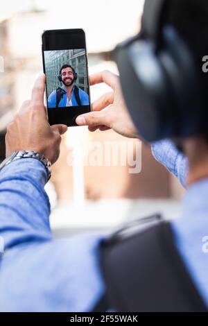 Geschäftsmann nimmt Selfie über Smartphone Stockfoto