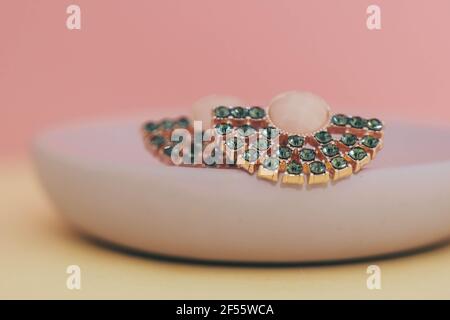 Nahaufnahme von Diamantohrringen isoliert auf pastellgelb und Rosa Hintergrund Stockfoto