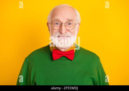 Foto von fröhlich positive reifen Mann gekleidet Pullover Fliege Gläser Lächelnder isolierter gelber Hintergrund Stockfoto
