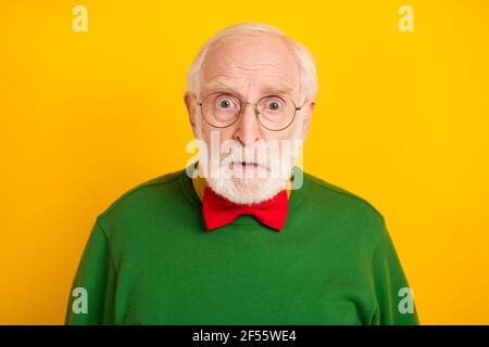 Foto von süß schockiert Alter Gentleman tragen Pullover Brille Fliege Große Augen isoliert gelben Hintergrund Stockfoto