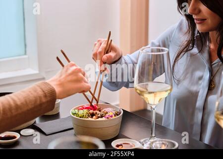 Weibliche Kundin, die im Restaurant Essen mit Essstäbchen serviert Stockfoto