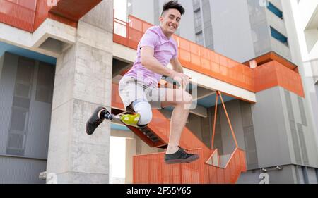 Sorgloser junger Amputekater, der gegen Gebäude springt Stockfoto