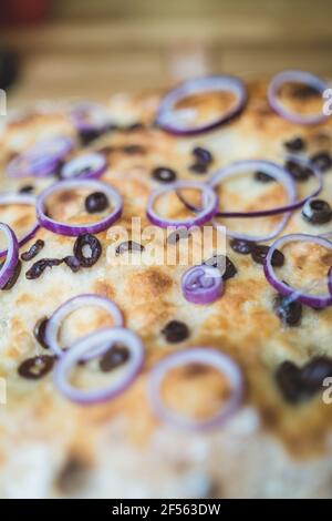 Focaccia Brot mit schwarzen Oliven und Zwiebel in Scheiben geschnitten Stockfoto