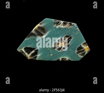 Fragment eines Gefäßes. Eine niedrige Krümmung des Glassfragmentes ermöglicht die Zuordnung zu einem Gefäß, möglicherweise einer Schale. Aus türkisfarbenem Grund sind mehrere Blumen in der millefiori-Technologie zu sehen. Die einzelnen Blüten bestehen aus einem roten Punkt mit gelbem Rand als Kern, um die braunen Punkte mit weißer Kontur als Blütenblätter zu legen. Für die Herstellung wurden verschiedenfarbige Gläser zu Rohren und Stäben geformt. Diese wurden komprimiert und erhitzt, was zu einem langen Balken führte. Die Glasscheiben hatten verschiedene amorphe oder florale Muster. ​​now Danach wurden mehrere dieser Thrombozyten zusammengefaltet, wieder erhitzt und gepresst Stockfoto