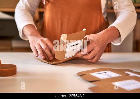 Frau, die in der Werkstatt handgemachte Seife in Schachteln verpackt Stockfoto