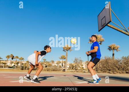 Vater und Sohn spielen mit Fußball auf dem Sportplatz Stockfoto