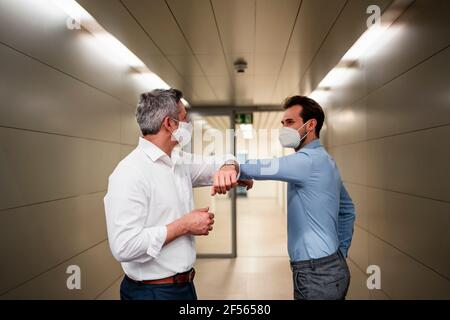 Männlicher Unternehmer, der während der COVID-19 Ellenbogenstoß machte Stockfoto