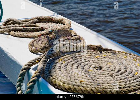 Horizontale Nahaufnahme von Seilspulen auf der Rasil eines Flussbootes, das während des Flußes in der Sonne trocknet. Stockfoto