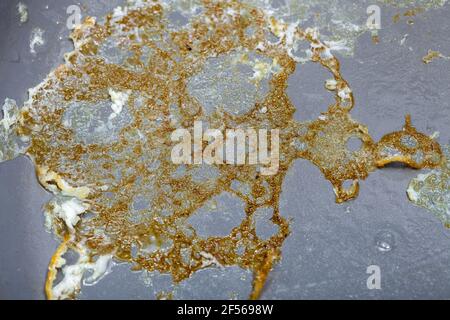 Gebrannte Kruste von Spiegeleiern in einer Keramikbratpfanne mit Antihaftbeschichtung aus Polytetrafluorethylen in der Nähe, schmutzige Küchenutensilien zum Kochen heißer Fritten Stockfoto