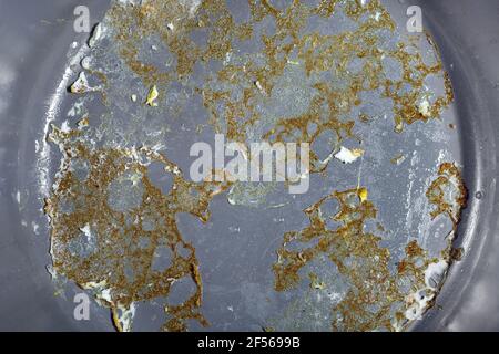 Graue Antihaftfläche einer Bratpfanne mit gebrannten Spiegeleiern aus der Nähe, Küchenutensilien zum Kochen gebratener Speisen, niemand. Stockfoto