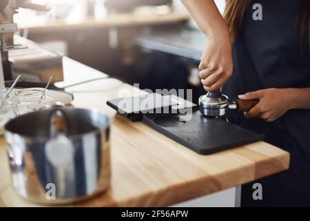 Nahaufnahme des Barista, der Kaffee eintampft, um das Beste zuzubereiten Erstaunliche Kaffee Schuss Sie gekostet haben Stockfoto