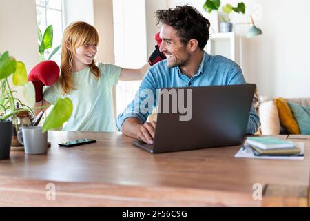 Spielerisch Rotschopf Mädchen Spaß mit Vater arbeiten auf Laptop Zu Hause Stockfoto