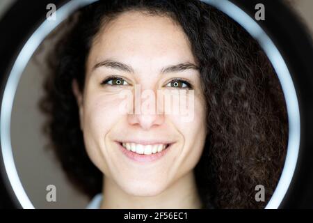 Lächelnde Frau vor dem Ringlicht Stockfoto