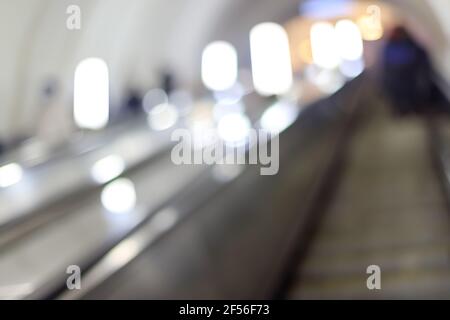 Verschwommenes oder defokussiertes Bild einer Rolltreppe für den Eingang zur Metropole, beleuchtet durch helle Lichter Stockfoto