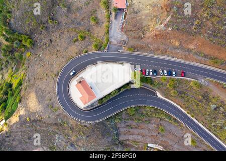 Spanien, Valle Gran Rey, Drohne Blick auf die Autobahn, die sich um die Kirche San Antonio schlängelt Stockfoto