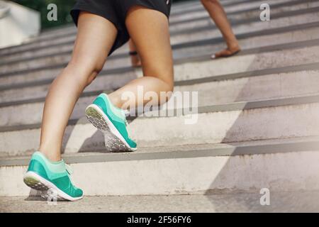 Nahaufnahme der Frau, die sich darauf vorbereitet, nach oben zu laufen oder Liegestütze zu tun. Urbanes Sportkonzept. Stockfoto