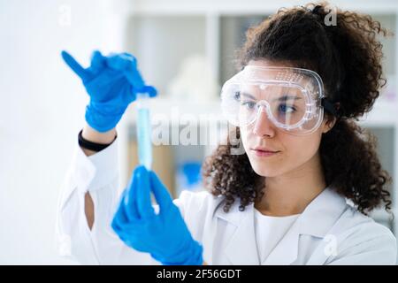 Forscherin untersucht chemische Lösung im Reagenzglas im Labor Stockfoto
