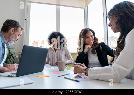 Männliche und weibliche Mitarbeiter diskutieren im Büro Stockfoto