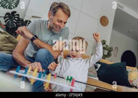 Glücklicher Junge, der Brettspiel mit Vater im Wohnzimmer spielt Stockfoto