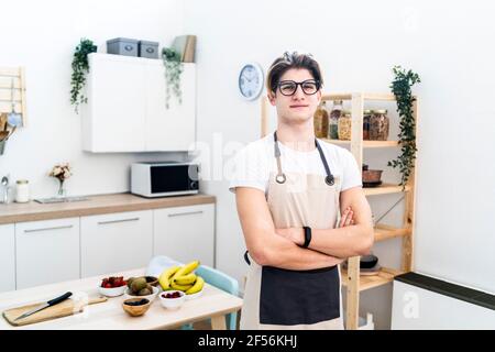 Mann mit Schürze, der in der Küche steht Stockfoto