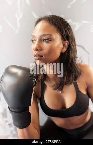 Junge Frau trägt Boxhandschuhe im Fitness-Studio Stockfoto