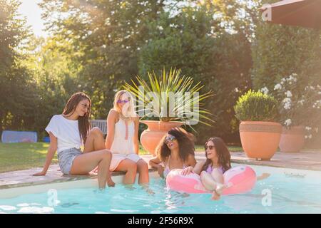 Fröhliche Freundinnen, die sich bei Sonnenschein im Schwimmbad amüsieren Tag Stockfoto