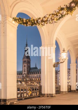 Deutschland, Hamburg, Alsterarkaden mit Weihnachtsschmuck und Blick auf das Rathaus bei Sonnenaufgang Stockfoto