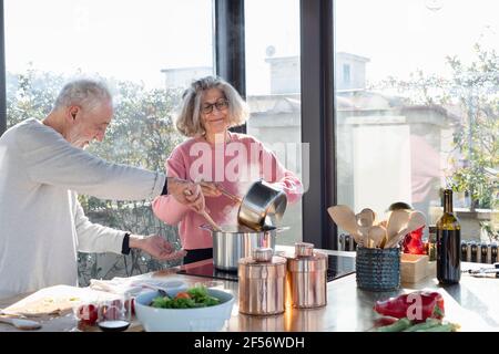 Seniorenpaar kocht zusammen, während sie zu Hause in der Küche stehen Stockfoto