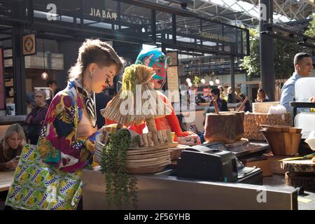 London, Großbritannien - 20. September 2020, Shopper bei Spitalfields Antic Market Market. Hell gekleidete Menschen kaufen Lebensmittel auf dem Lebensmittelmarkt Stockfoto