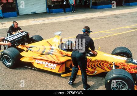 2001 Donington Park Rennbahn ,Castle Donington ,Leicestershire ,East Midlands, England, GB, UK, Europa - Paul Stoddart fährt Neale Clark in einem europäischen Formula Racing Zweisitzer Minardi F1 Rennwagen aus den Boxen auf der Donington Park Rennbahn. Diese bemerkenswerte zweisitzige Racing Car Passenger Ride gibt einen Nervenkitzel in halsbrecherischer Geschwindigkeit für eine Eimer Liste Erfahrung des Lebens. Paul Stoddart, ab dem Grand Prix von Spanien 2017, bietet Fans die Möglichkeit, in einem seiner Minardi FX2 Autos fahren Stockfoto