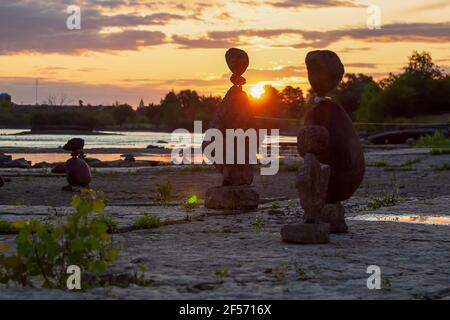 Balanced-Rock-Kunst an einem Strand bei Sonnenaufgang - Zeit zu Begrüßen Sie den Tag Stockfoto