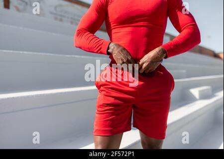 Nicht erkennbarer kurzer Athletic Mann in Sportbekleidung Anordnung Shorts. Stockfoto
