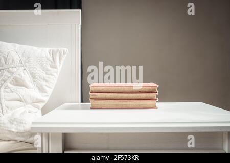 Bücher auf Retro-weißen Tisch für Bett skandinavische Einrichtung neutrale Farbpalette. Stockfoto