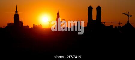 München, Deutschland. März 2021, 24th. Die Sonne untergeht hinter der Skyline der bayerischen Hauptstadt. Von links nach rechts sind die Türme der Peter-Kirche (Alter Peter), das Rathaus und die Frauenkirche zu sehen. Quelle: Sven Hoppe/dpa/Alamy Live News Stockfoto