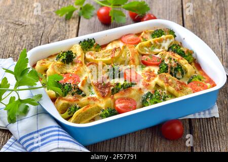 Vegetarischer Auflauf mit geschnittenen schwäbischen Gemüseravioli, Tomaten, Brokkoli und Käse, heiß aus dem Ofen serviert Stockfoto