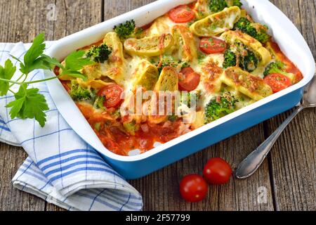 Vegetarischer Auflauf mit geschnittenen schwäbischen Gemüseravioli, Tomaten, Brokkoli und Käse, heiß aus dem Ofen serviert Stockfoto