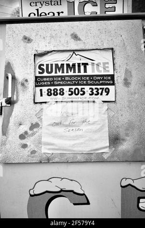 Nahaufnahme der Eisbox am Rastplatz. Schild mit der Marke Summit Ice an der Tür. Handgeschriebenes Schild mit „Ice out for the season“ an der Tür. Stockfoto
