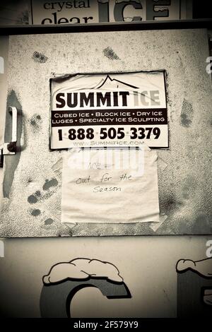 Nahaufnahme der Eisbox am Rastplatz. Schild mit der Marke Summit Ice an der Tür. Handgeschriebenes Schild mit „Ice out for the season“ an der Tür. Stockfoto