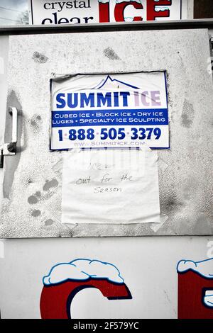 Nahaufnahme der Eisbox am Rastplatz. Schild mit der Marke Summit Ice an der Tür. Handgeschriebenes Schild mit „Ice out for the season“ an der Tür. Stockfoto