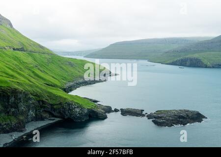 Dramatische Aussicht auf die grünen Hügel der Insel Vagar und Sorvagur Stadt Stockfoto