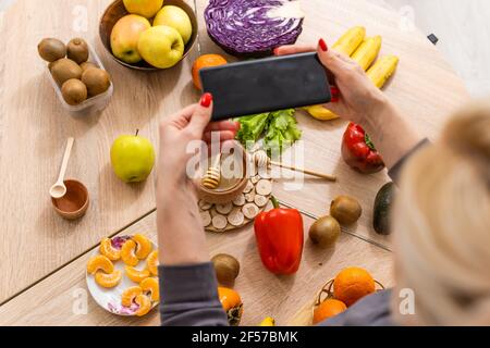 Frau mit Kalorienzähler Anwendung auf ihrem Smartphone Stockfoto