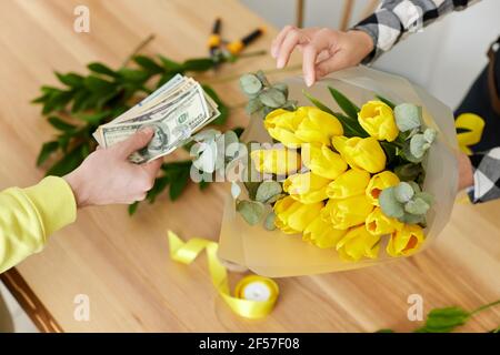 Frau Floristin verkauft Blumen an einen Mann Stockfoto