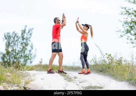 Junge Läuferinnen geben nach dem Lauf fünf hohe Punkte Stockfoto