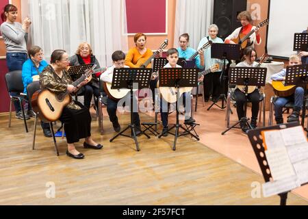 Saint-Petersburg, Russland-circa Jan, 2020: Klassisches Musikkonzert für Eltern ist in der russischen Kindermusikschule. Jungen und Mädchen mit Erwachsenen spielen qui Stockfoto