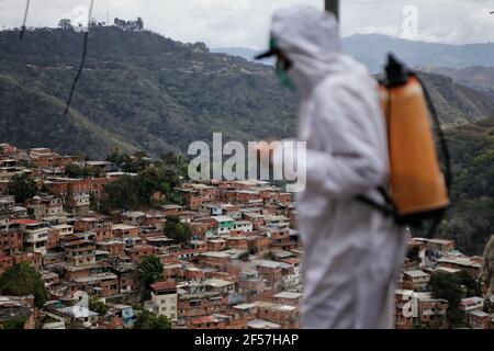 Sucre, Venezuela. März 2021, 24th. Ein Mitarbeiter der Stadtregierung von Sucre sprüht eine Lösung aus Hypochlorit und Wasser, um eine Infektion mit dem Covid-19 in den Straßen des Cuatricentenario-Sektors des beliebten Viertels Petare zu verhindern. Kredit: Jesus Vargas/dpa/Alamy Live Nachrichten Stockfoto