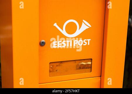 Oranger Briefkasten mit altem Logo der estnischen Post ist auf dem Land noch auf Stand. Von 2014 hat es neues Logo und Namen der Omniva angenommen. Estoni Stockfoto