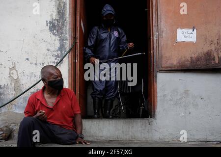 Sucre, Venezuela. März 2021, 24th. Ein Arbeiter aus dem Büro des Bürgermeisters von Sucre sprüht eine Lösung aus Hypochlorit und Wasser, um die Ausbreitung von Covid-19 im Haus einer behinderten Person im Sektor Cuatricentenario des beliebten Viertels Petare zu verhindern. Kredit: Jesus Vargas/dpa/Alamy Live Nachrichten Stockfoto