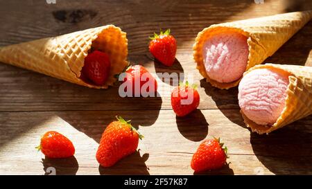 Erdbeereis in einem Waffelkegel. Rote Beeren und Eiskugeln Stockfoto